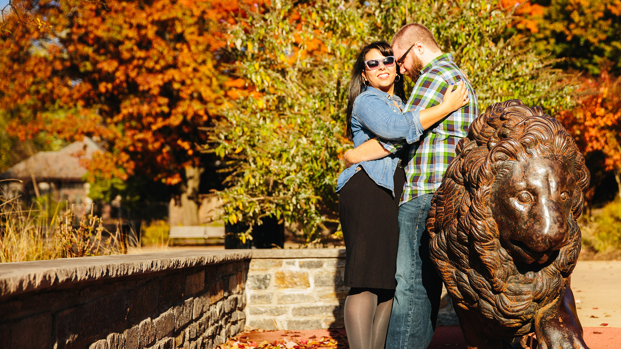 couple standing together beside iron lion statue